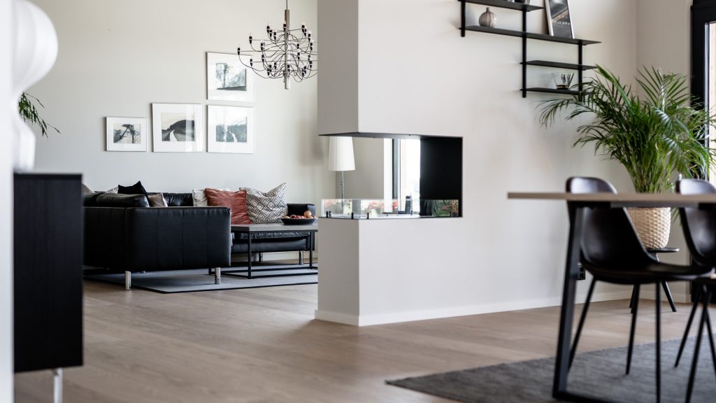Villa Avaberg – öppen planlösning med vardagsrum, dubbelsidig kamin och matplats
